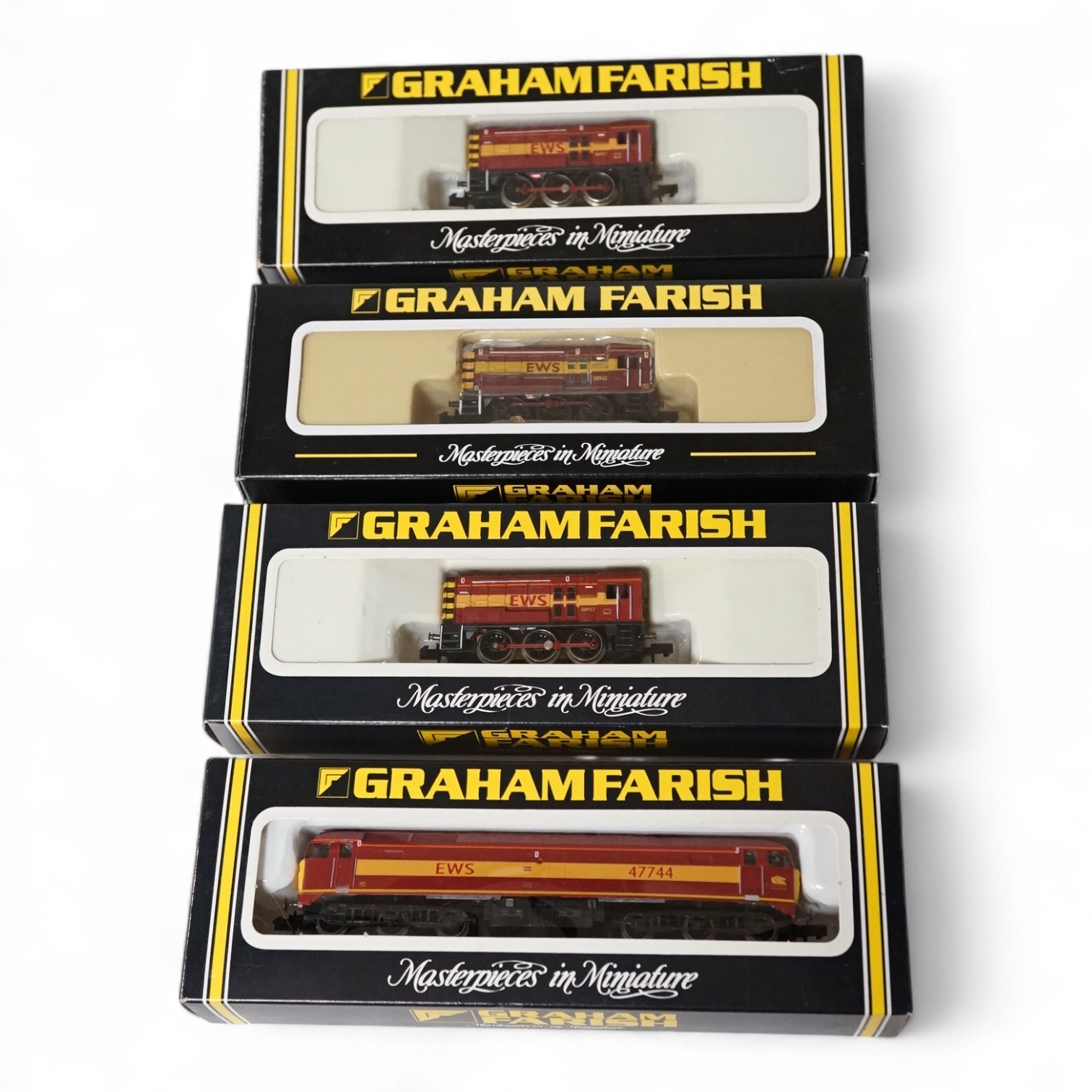Four boxed Graham Farish N gauge railway EWS diesel locomotives; three Class 08; 08921 (100G), 08933 (371-002), and 08957 (100F) together with a Class 47; 47744 (802C). Condition - good.